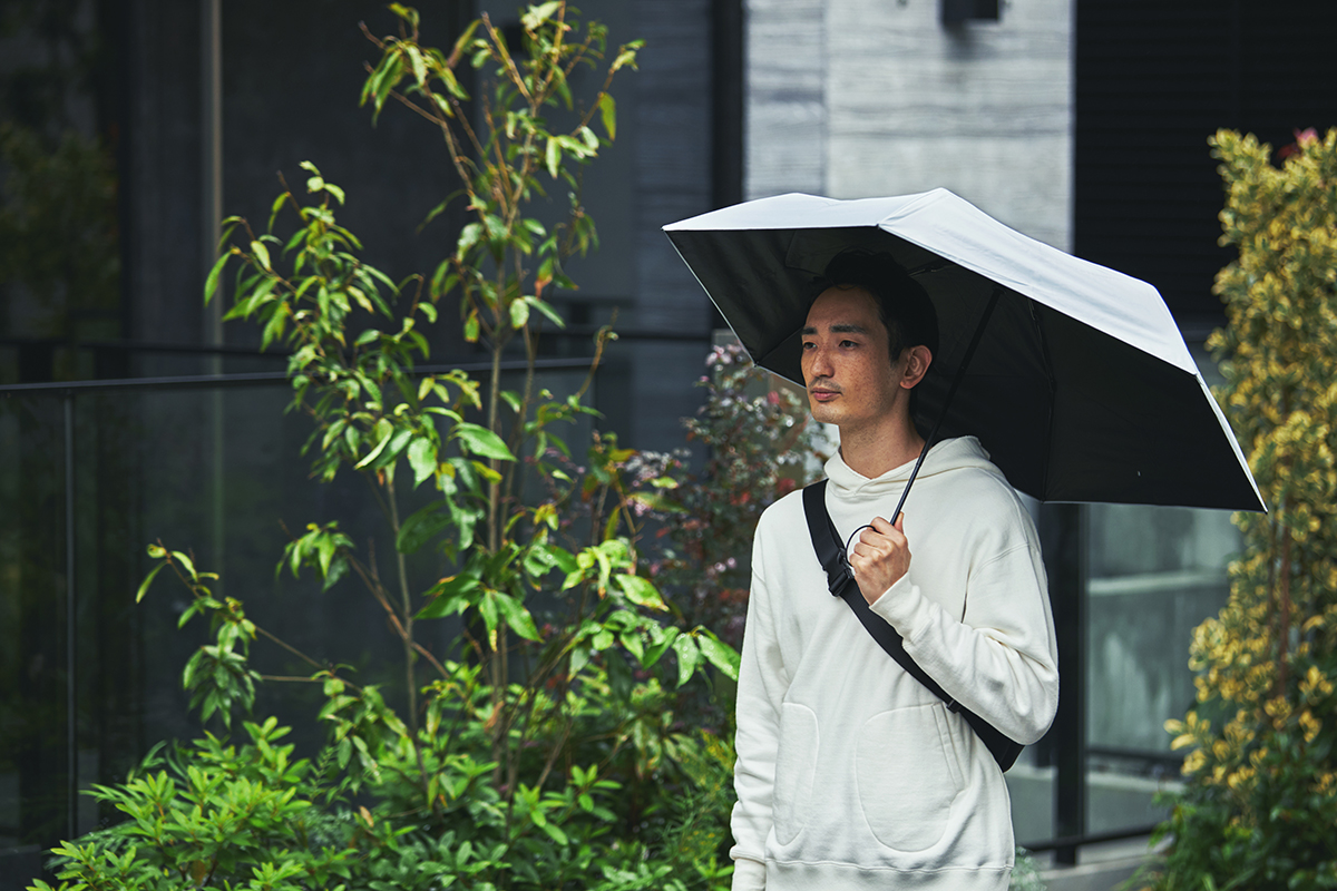 雨の中、バスやタクシー、車へ乗り込むときも、傘をたたむ時間はほんの1秒。驚くほど軽い!完全遮光タイプの「ワンタッチ開閉式折りたたみ傘(晴雨兼用)」|VERYKAL HEAT BLOCK