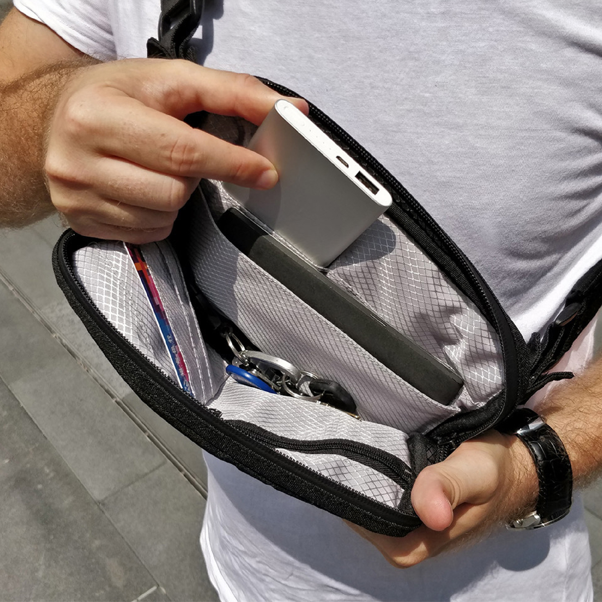 Image: https://1fl0kyr79c.user-space.cdn.idcfcloud.net/photographes/85eb698156842b1092444e22cbba8e02.jpg 大容量のスマホ充電器でも、難なく収納が可能。移動しながらスマホ充電できる、着る財布(ボディーバッグ型財布)|Code10