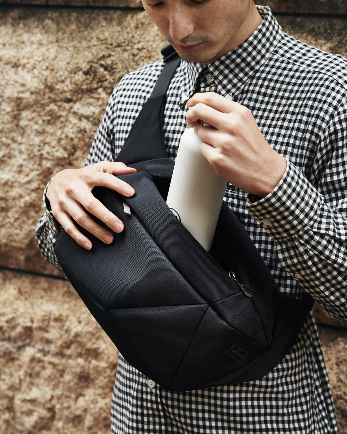 財布やスマホといった必需品はもちろん、上着までスッポリ。タブレットが入るテックポケットもついています。「石」から発想したミニマルデザイン、タブレットと上着を入れても型崩れしない「ボディバッグ」|STONE SLING(ストーン スリング)